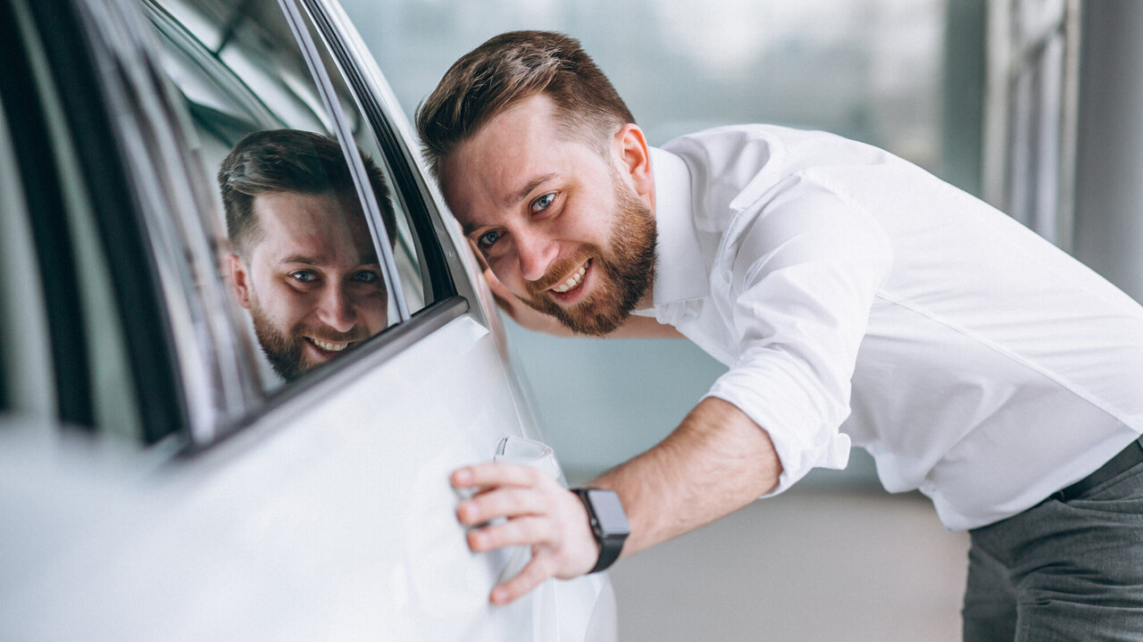 Ein Mann liebkost sein Auto