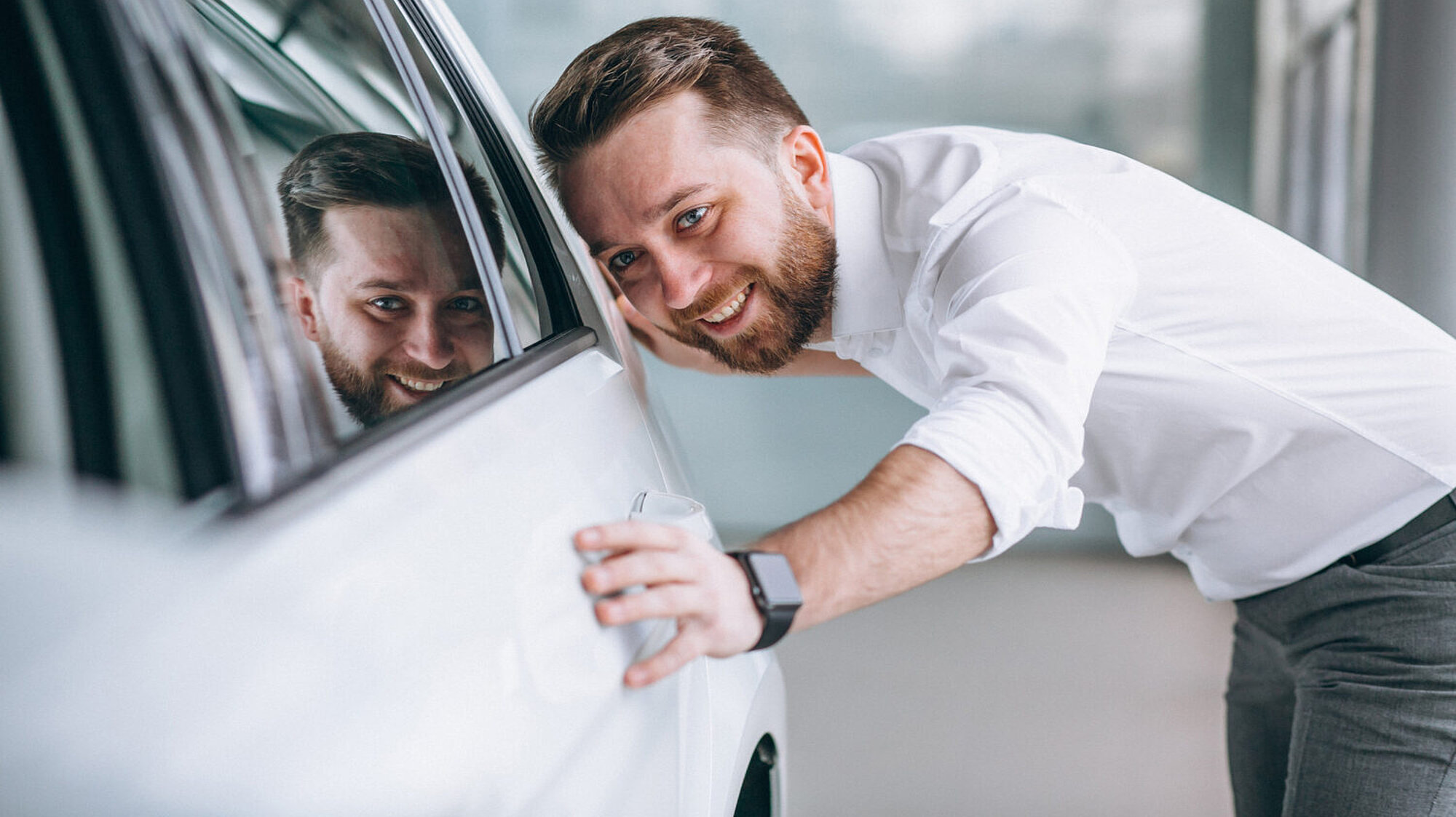 Ein Mann liebkost sein Auto