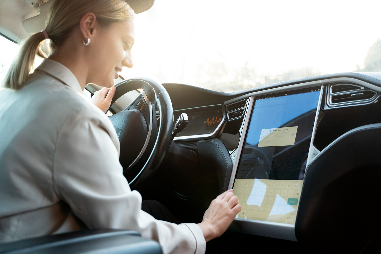 Frau bedient Touchscreen im Auto