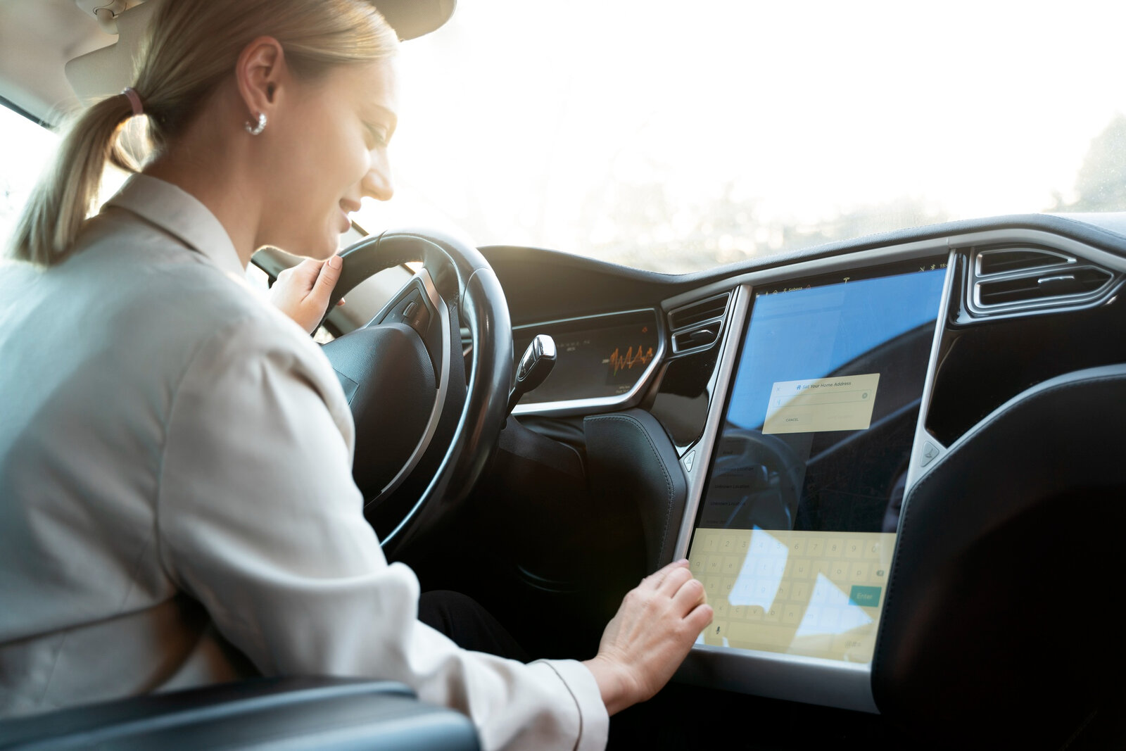 Frau bedient Touchscreen im Auto