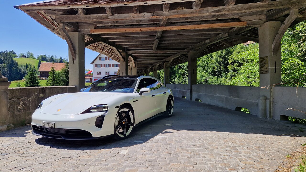 Der Porsche Taycan GTS Sport Turismo fährt von einer Brücke