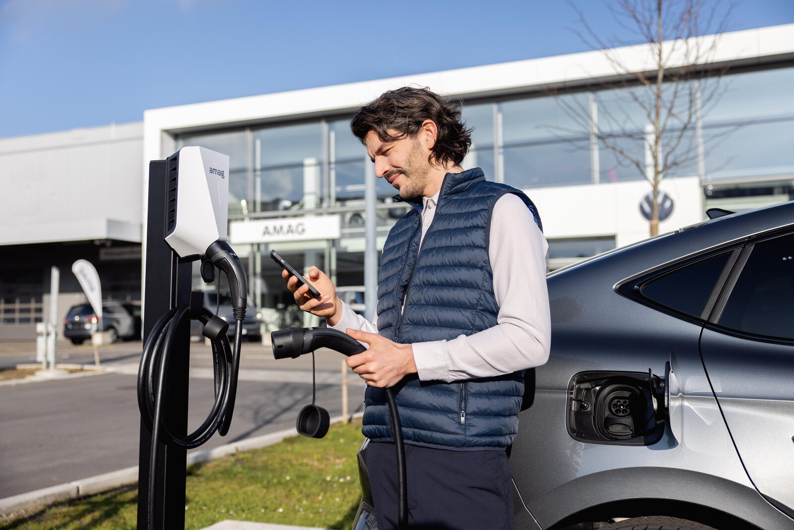 Ein Mann startet den Ladevorgang seines Elektroautos