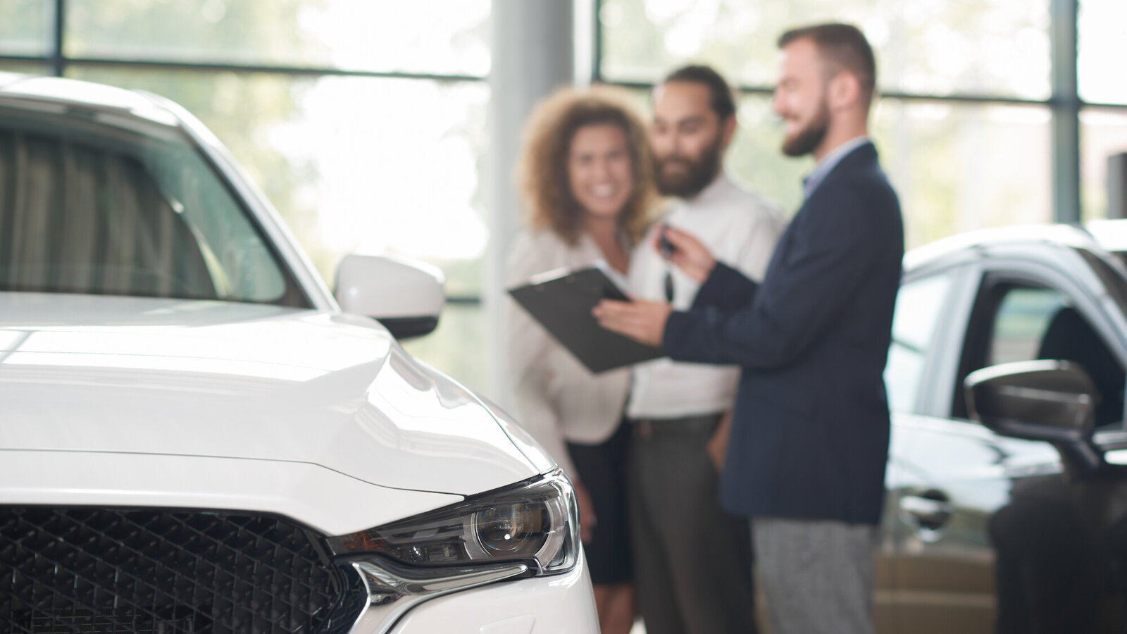 Blick über die Motorhaube eines Autos auf ein Verkaufsgespräch