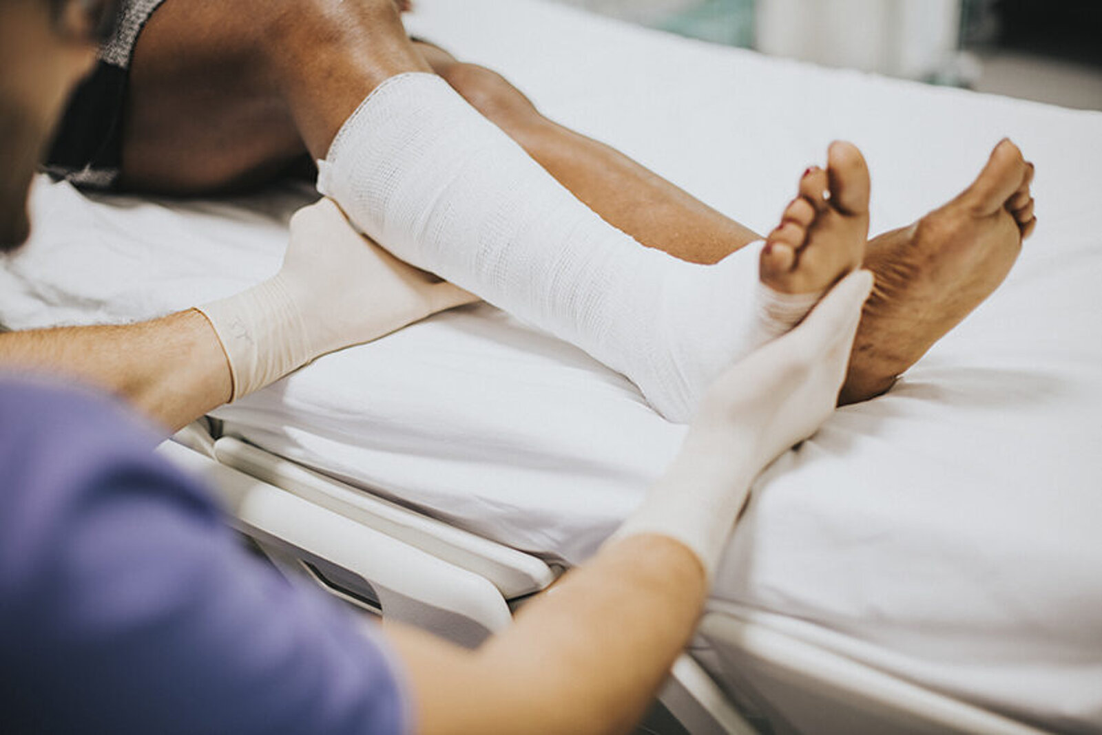 Arzt hilft einem Patienten mit einem gebrochenen Bein