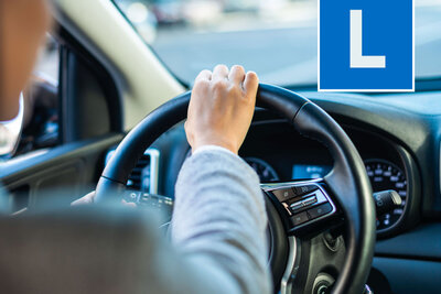 Autofahrer über die SChulter blickend mit L auf Bild