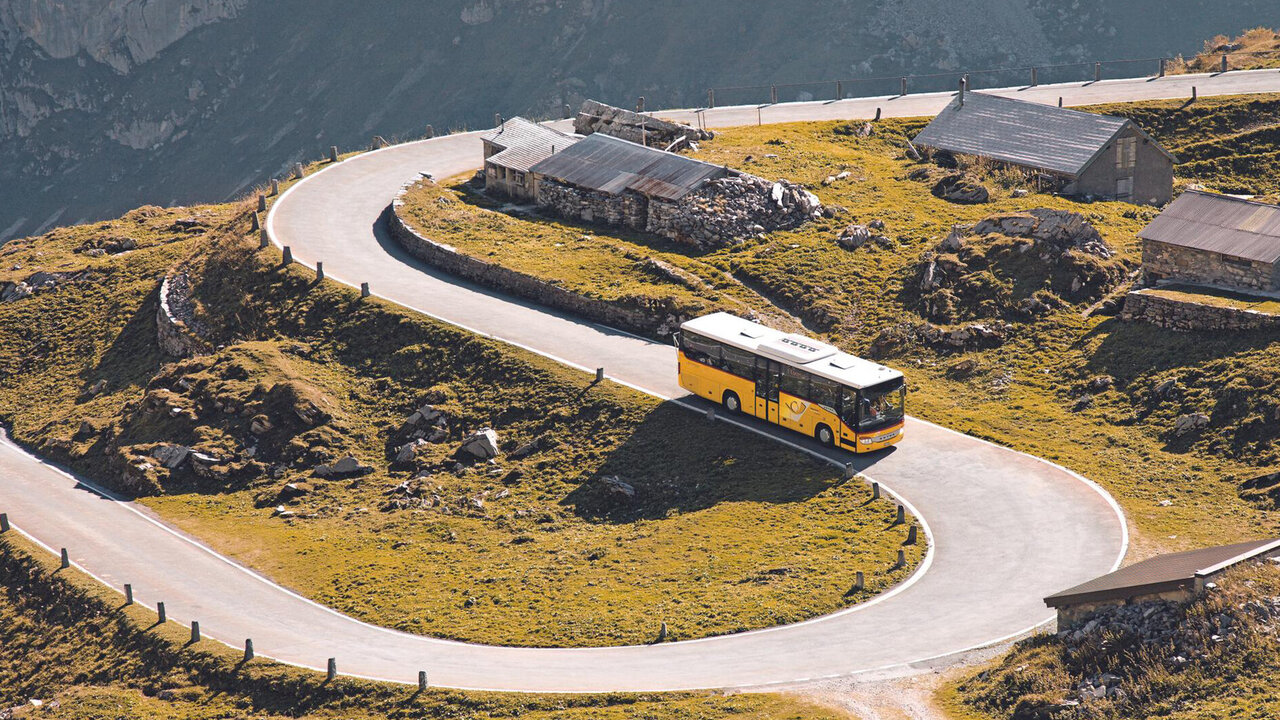 Ein Postauto auf einer kurivgen Bergstrasse