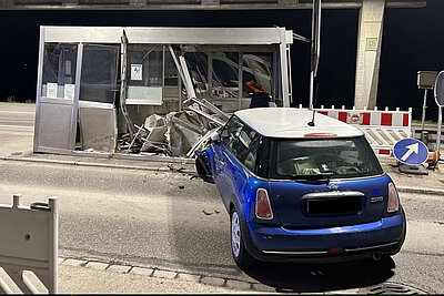 Beschädigtes Auto und Zollhäuschen
