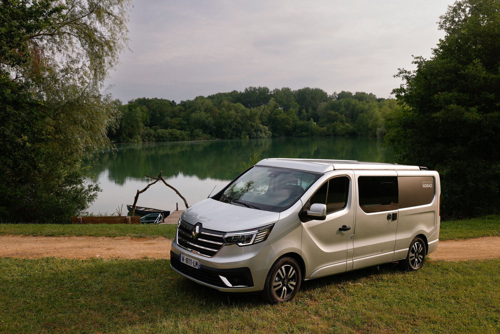 Der 5,40 Meter lange Renault Trafic Grand Spacenomad steht abfahrbereit an einem See.