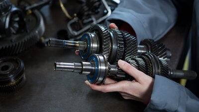 Getriebebauteile in der Hand einer Mechanikerin