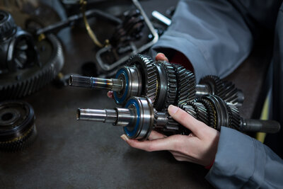 Getriebebauteile in der Hand einer Mechanikerin