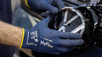 Hand setzt VW-Logo bei einem Auto ein