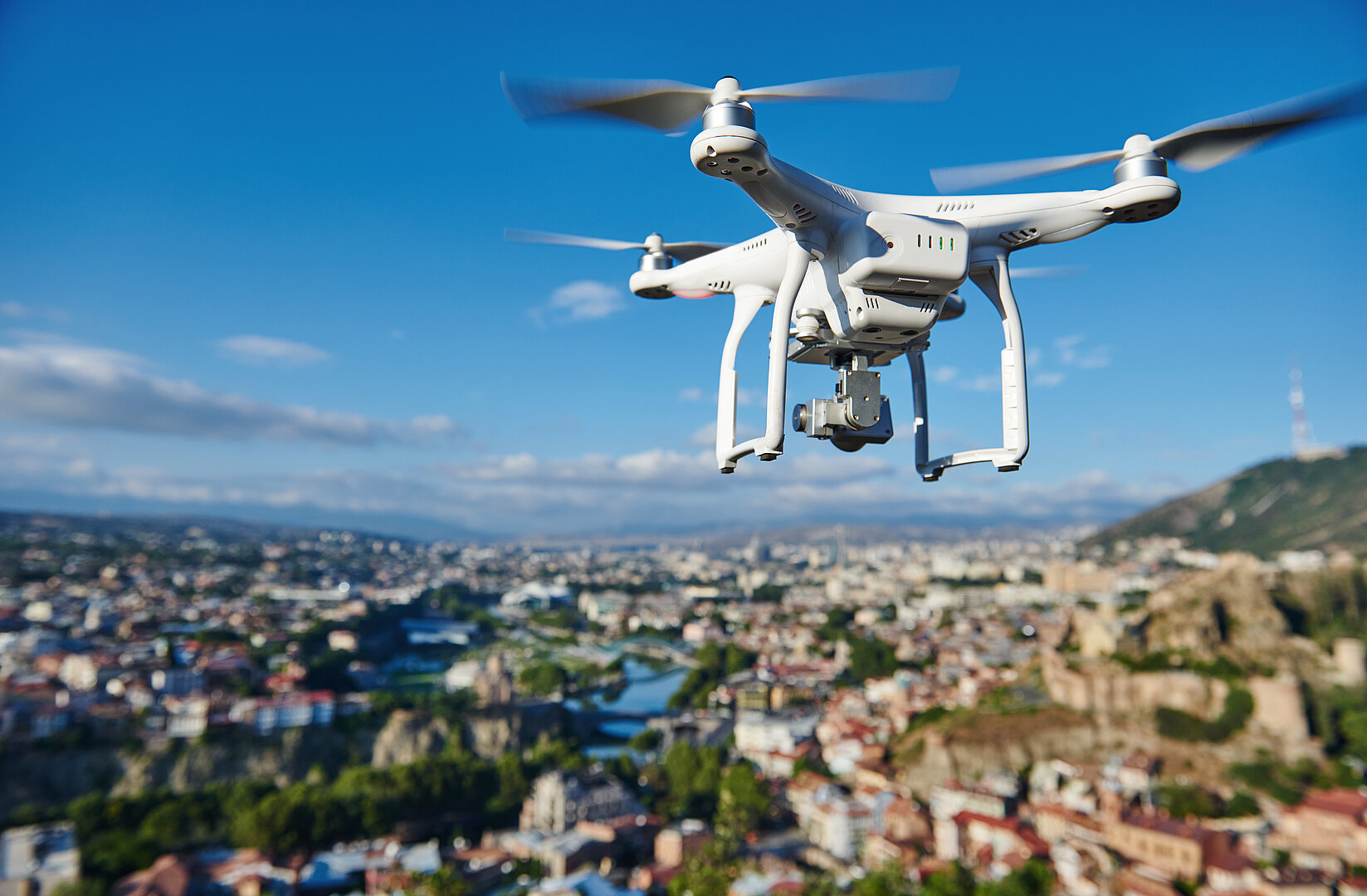 drone with digital camera hovering over city Drohne über einer Stadt