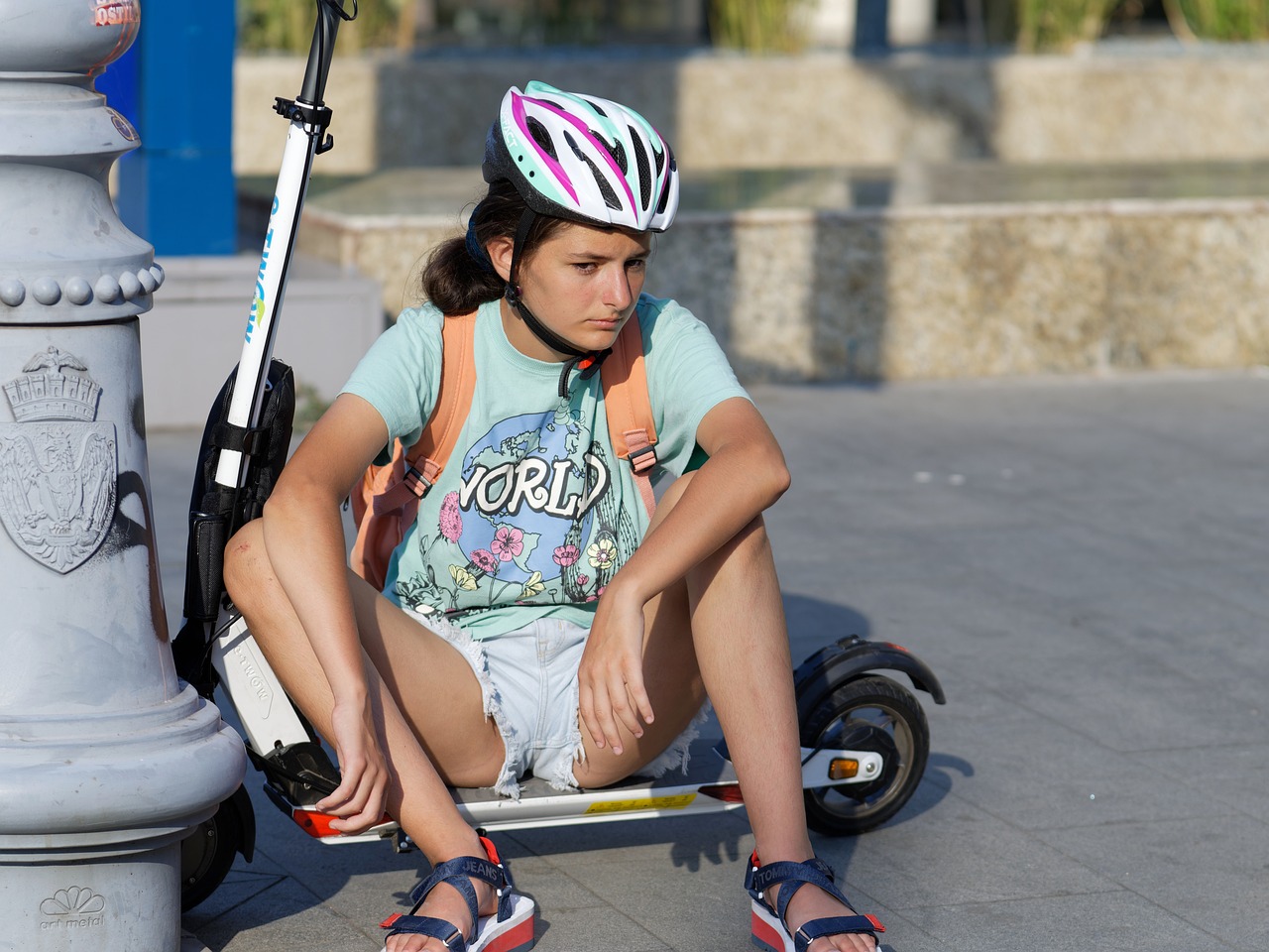 Frau sitzt auf Trottinette