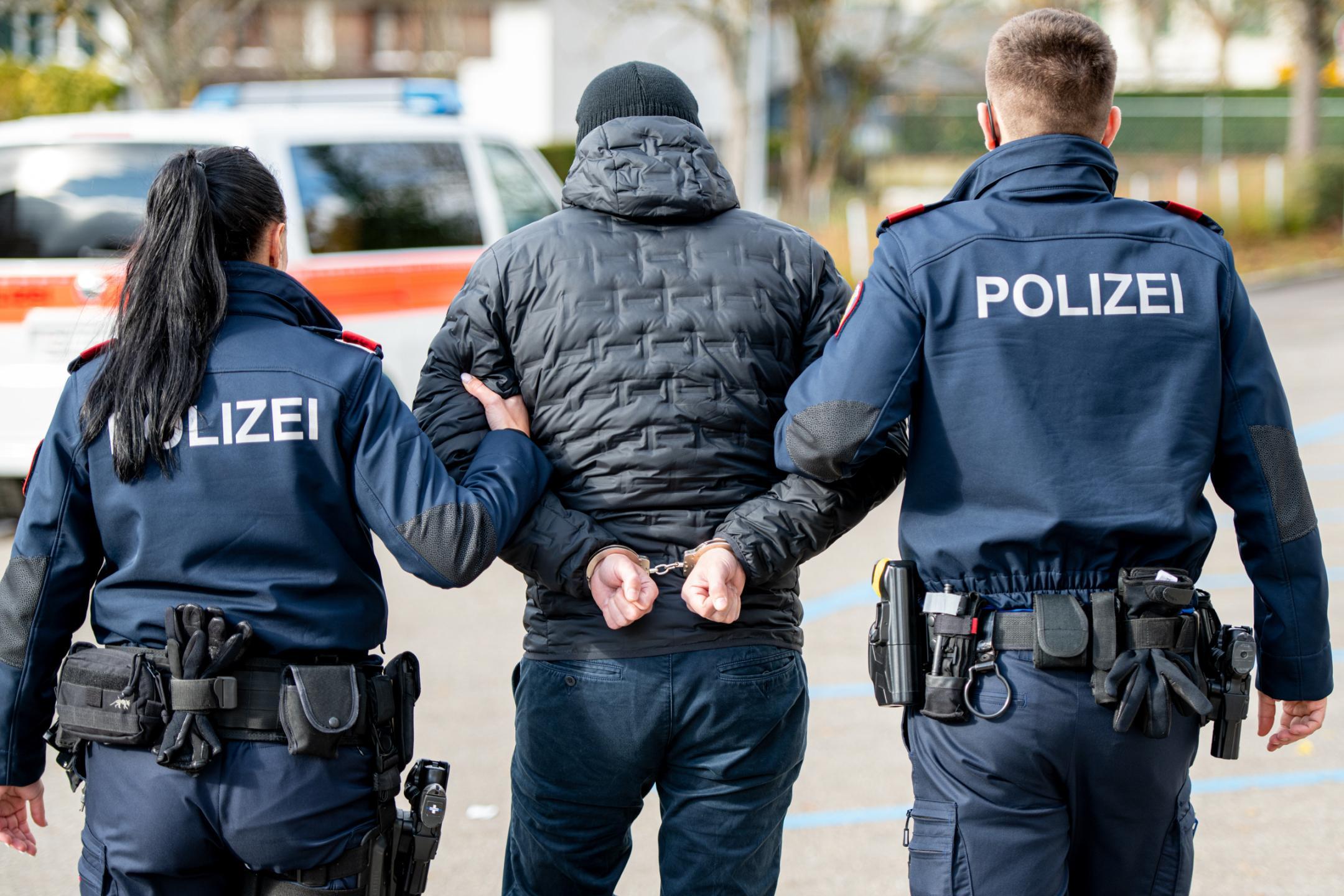 Polizei führt Verdächtigen in Handschellen ab